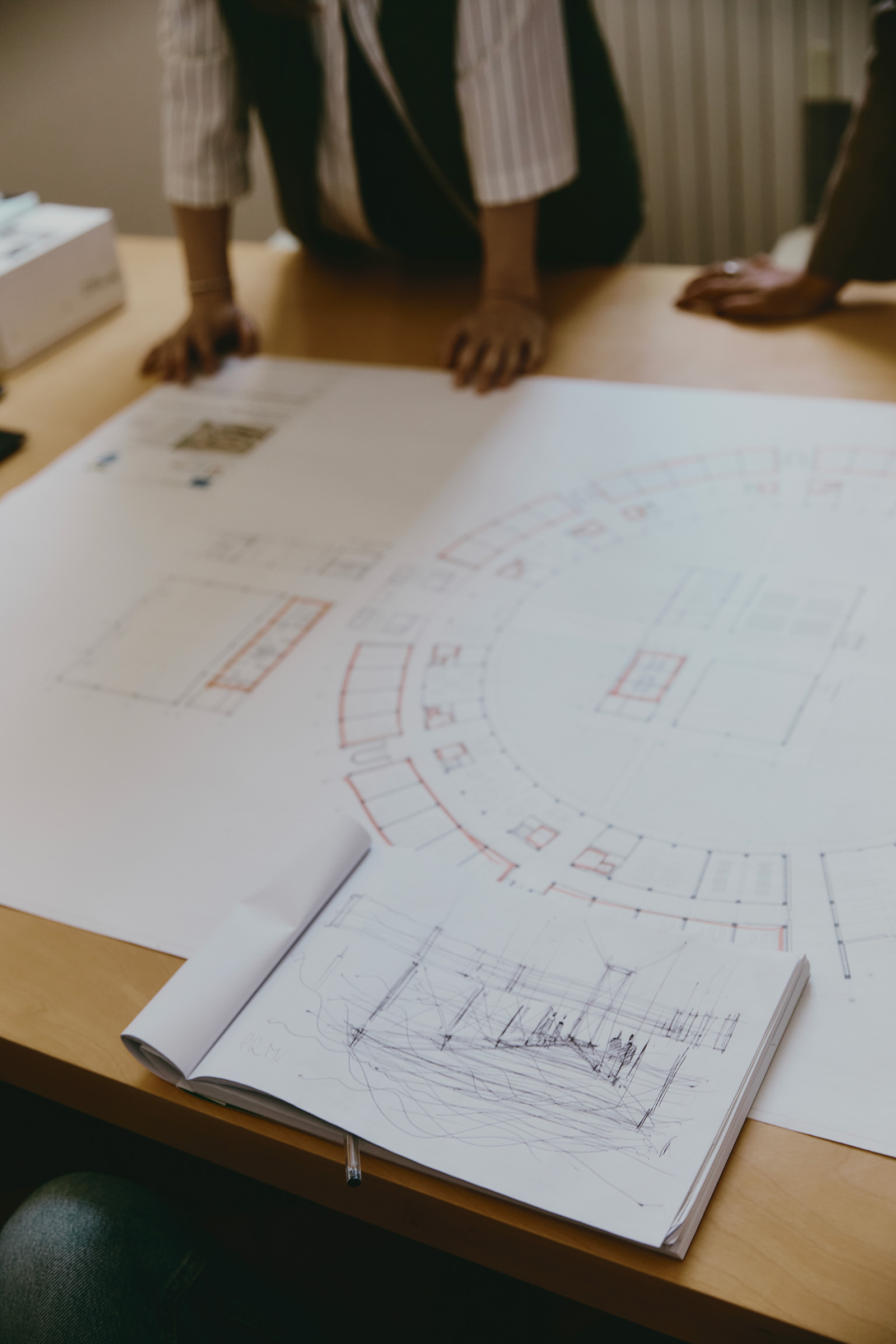 foglio con prospetto di progetto architettonico appoggiato su un tavolo in legno