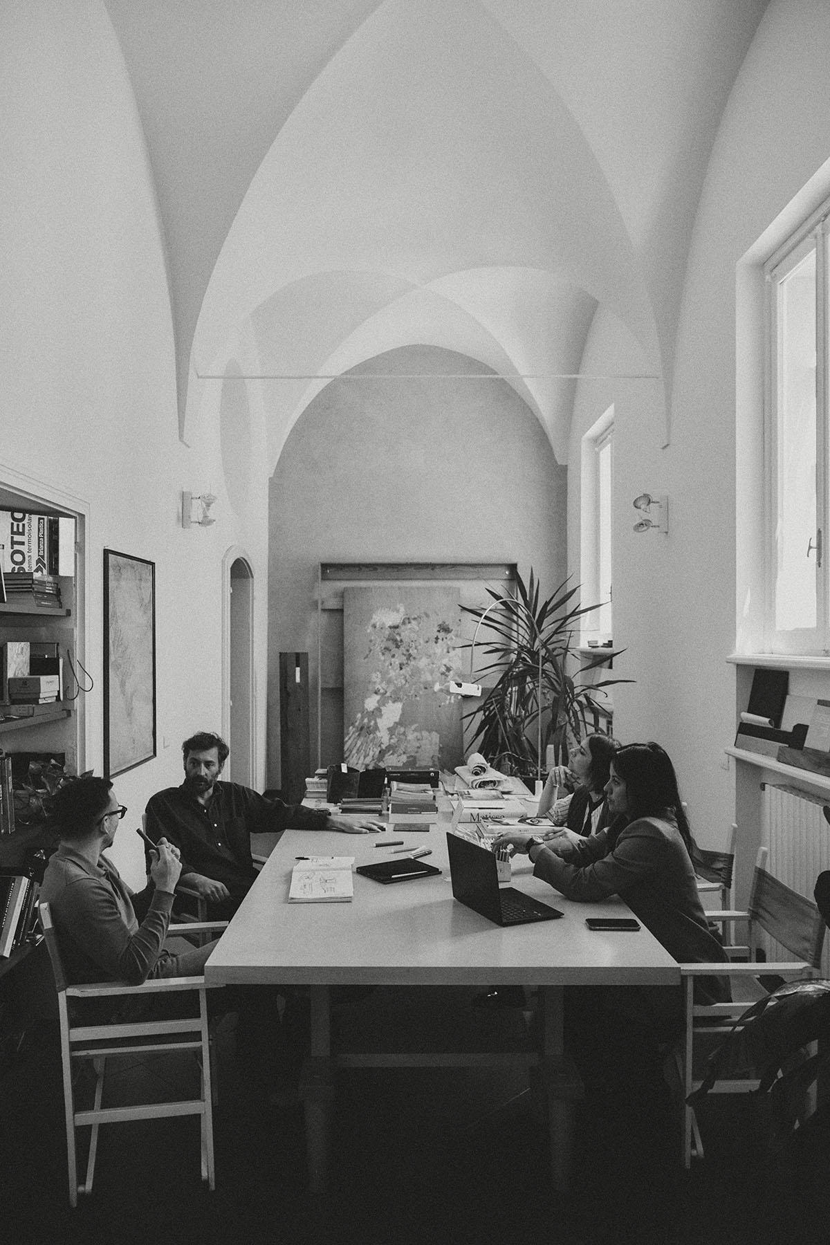 foto degli architetti di BFSA seduti intorno ad un grande tavolo all'interno di una stanza con volte
